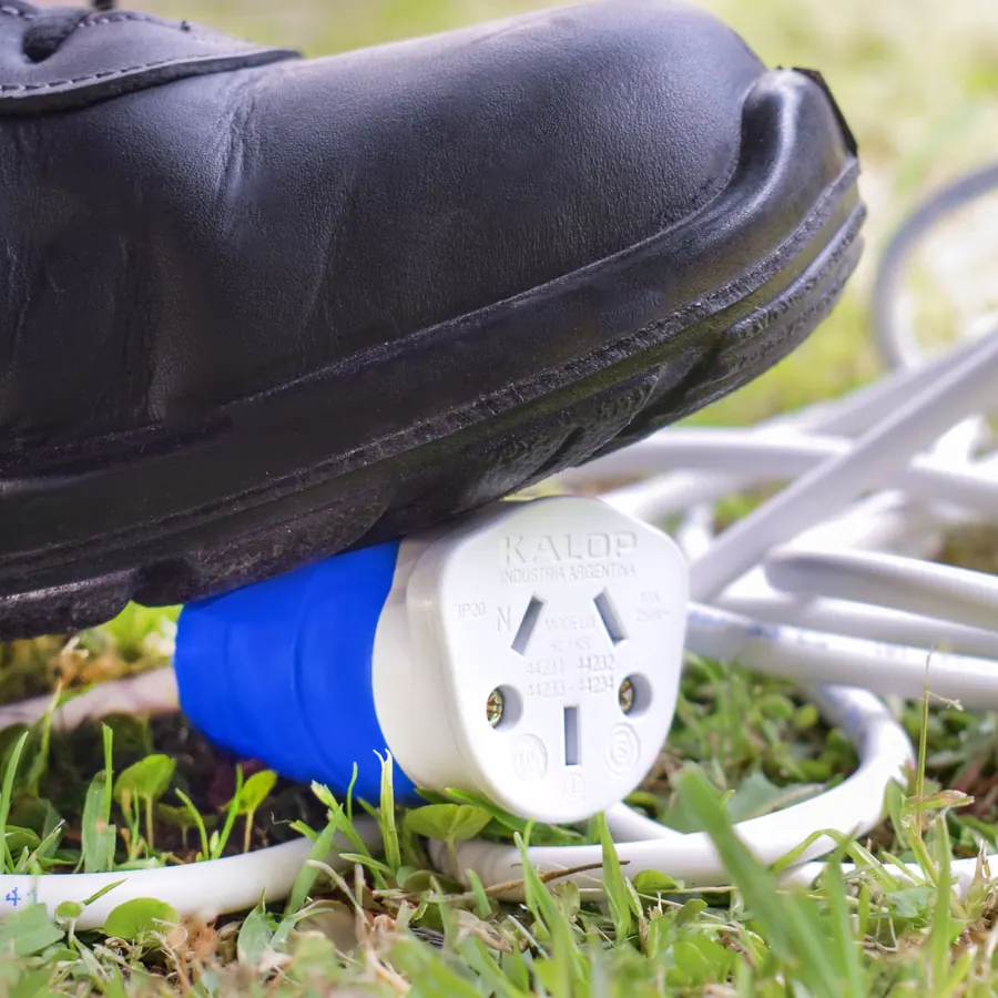 Una bota pisa una ficha Heavy Duty azul sobre el pasto